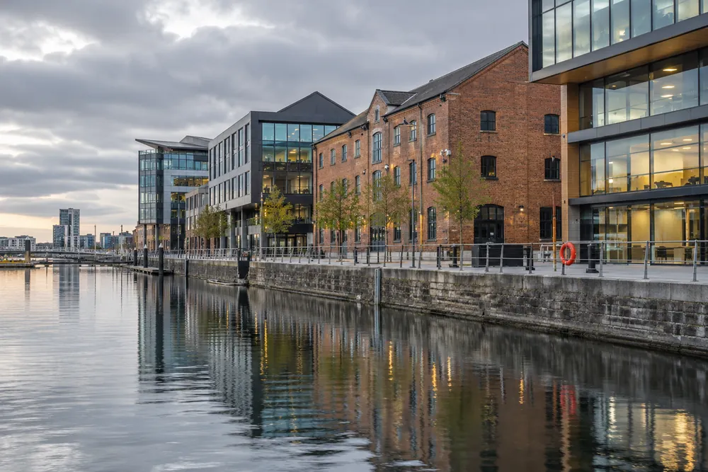 Brick and glass waterfront buildings reflected in the water at Cardiff Bay